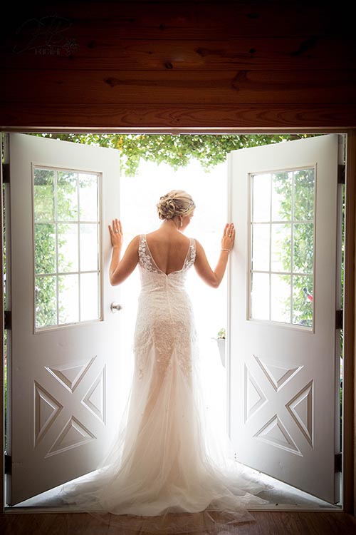 Beautiful bride poses in front of Entry doors